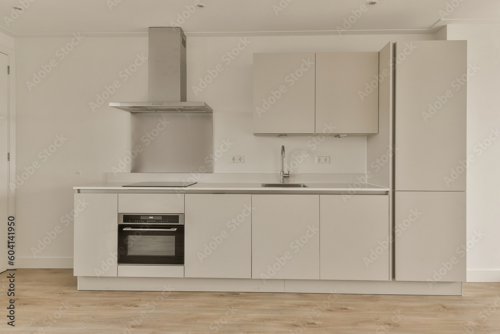 a kitchen with white cabinets and an oven in the center of the photo is taken from the doorway to the right a kitchen with white cabinets and an oven in the center of the photo is taken from the doorway to the right
