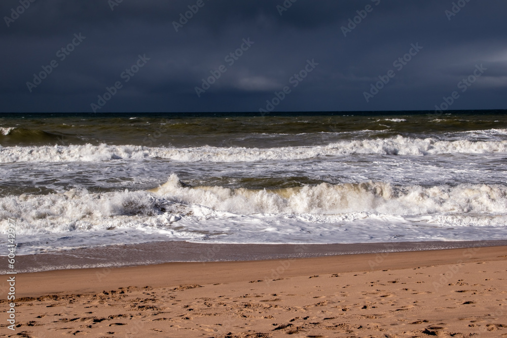 Empty wild sandy beach, Atlantic Ocean seascape, sea waves, beautiful cloudscape, dramatic landscape, travel content, Lisbon, Portugal