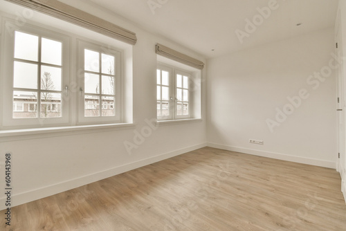 an empty room with white walls and wood flooring  there is a window in the wall to the right