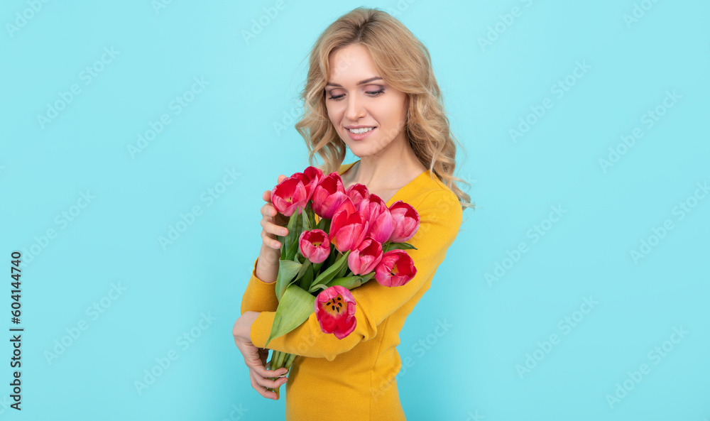 happy girl holding spring tulip flowers on blue background happy girl holding spring tulip flowers on blue background