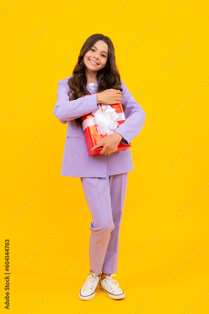 Teenager child holding gift box on yellow isolated background. Gift for kids birthday. Christmas or New Year present box. Teenager child holding gift box on yellow isolated background. Gift for kids birthday. Christmas or New Year present box.