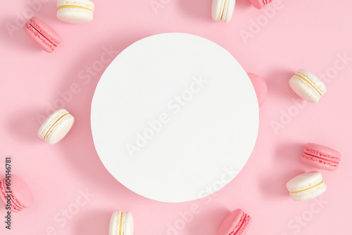 Colorful sweet french desserts.Vanilla and strawberry sweet french cookies. Cake macaroons or macaroon on pink background with round space for text, pastel colors. 