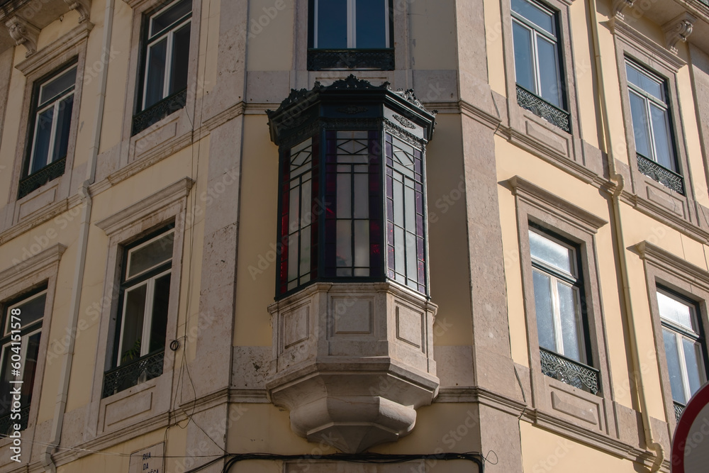 Facade of an old house with red bay window, European historical buildings, Lisbon, Portugal