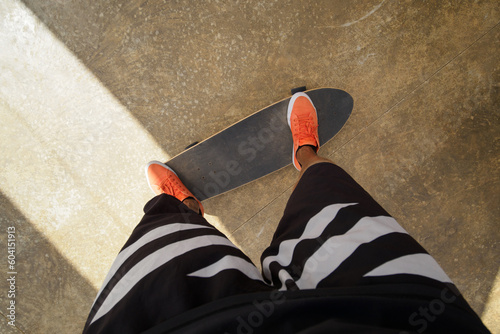 Point of view shot of skateboarder rides on skateboard in orange sneakers Fototapet