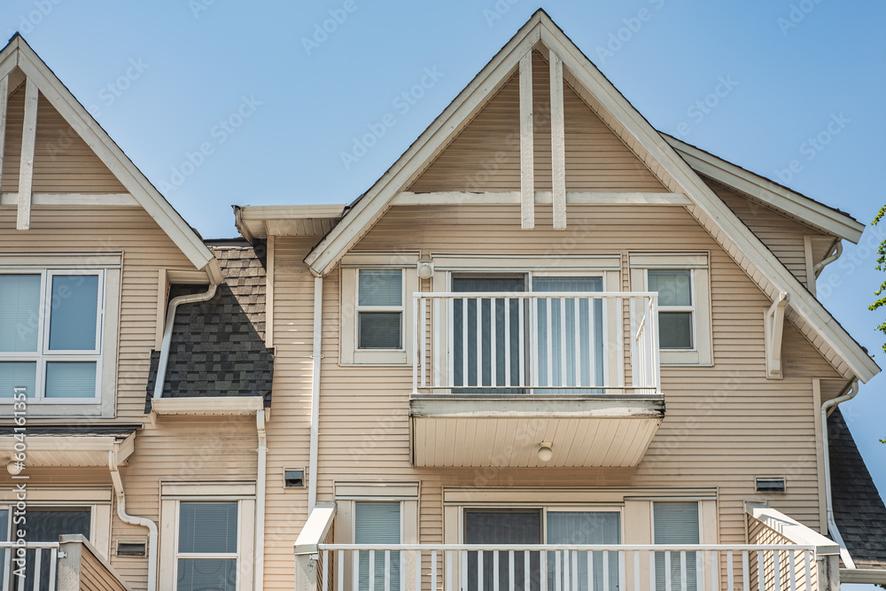 Houses in suburb in the north America. Top of a house with nice windows over blue sky. Beautiful Home Exterior