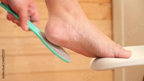 A metallic foot file for pedicure. One side is rough. It is designed to remove dead skin and calluses from the feet, leaving them smooth and soft. A great addition to anyone's self-care routine.