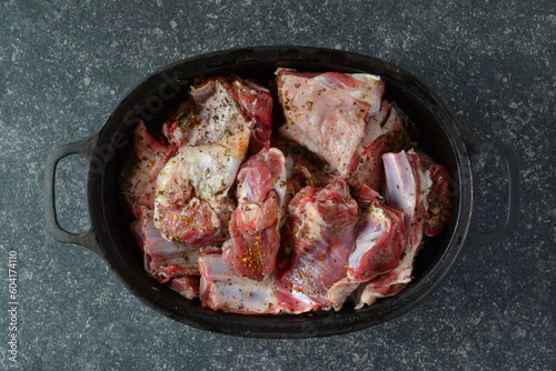 Seasoned lamb meat in black iron pot, top view