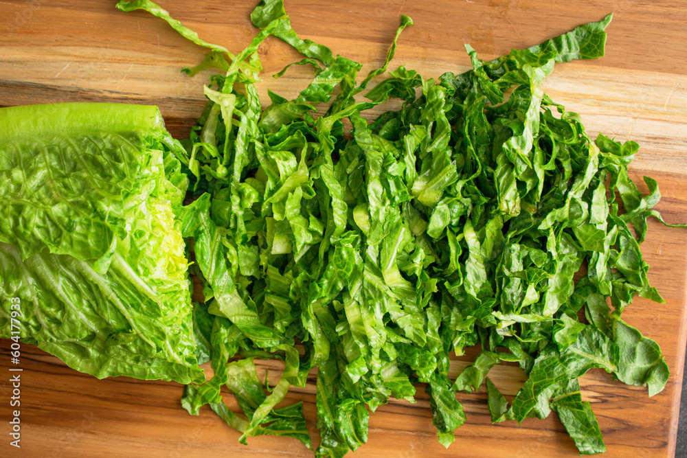Thinly Sliced Heart of Romaine Close-up: Sliced romaine lettuce on a wooden cutting board Thinly Sliced Heart of Romaine Close-up: Sliced romaine lettuce on a wooden cutting board