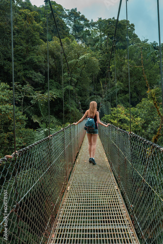 Arenal Hanging Bridges, young woman hiking in green tropical jungle, Costa Rica, Central America. photo