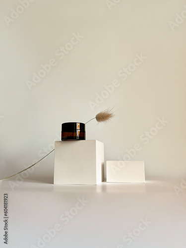 Container for cosmetics and creams. Glass brown jar for oil Beige background. Monochrome concept. Place for a label. Cream jars. Beauty and care. Minimalism