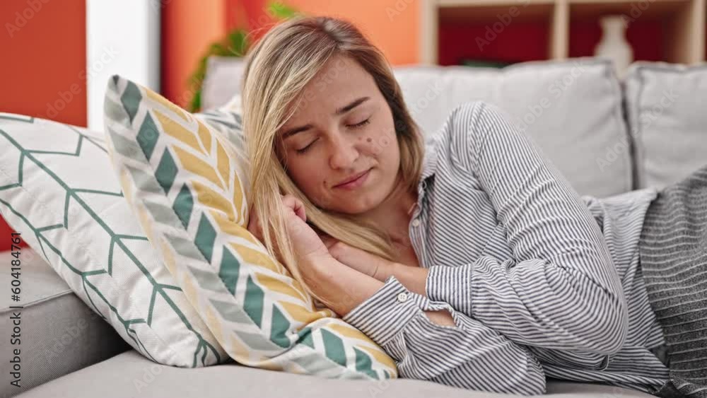 Young blonde woman lying on sofa sleeping at home Young blonde woman lying on sofa sleeping at home