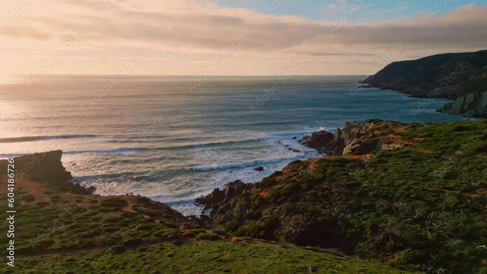 Evening surf washing hills with low greenery. Calm water rolling sunny cliffs Evening surf washing hills with low greenery. Calm water rolling sunny cliffs