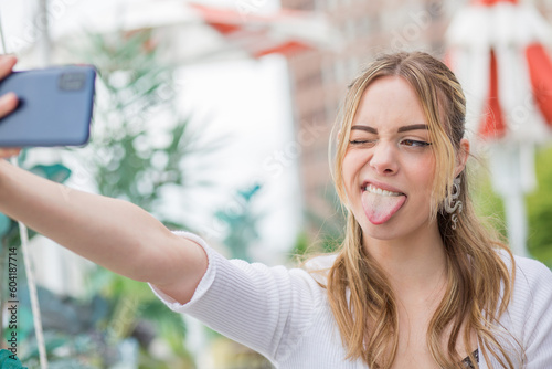 Young woman taking selfie on street