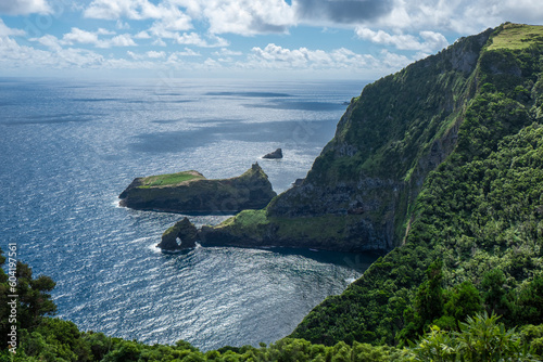 View of the shore from Miradouro do Ilheu Furado with a natural arch in the sea, Flores island, Azores islands, Portugal, Atlantic Ocean photo