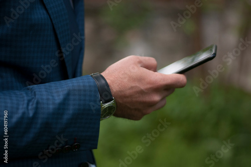 businessman in a blue suit waiting for the meeting in the garden of the workplace