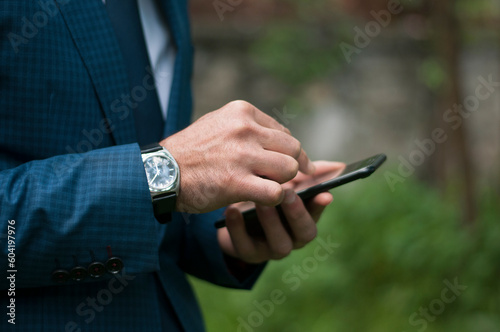 businessman in a blue suit waiting for the meeting in the garden of the workplace