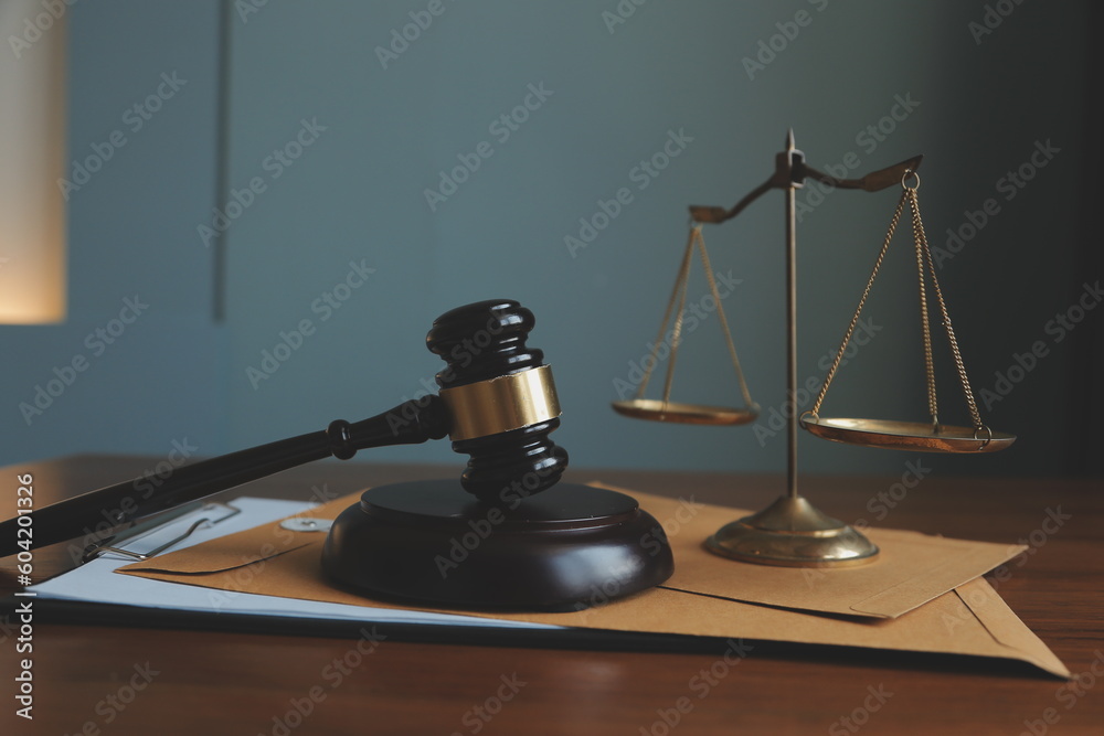 Business and lawyers discussing contract papers with brass scale on desk in office. Law, legal services, advice, justice and law concept picture with film grain effect Business and lawyers discussing contract papers with brass scale on desk in office. Law, legal services, advice, justice and law concept picture with film grain effect