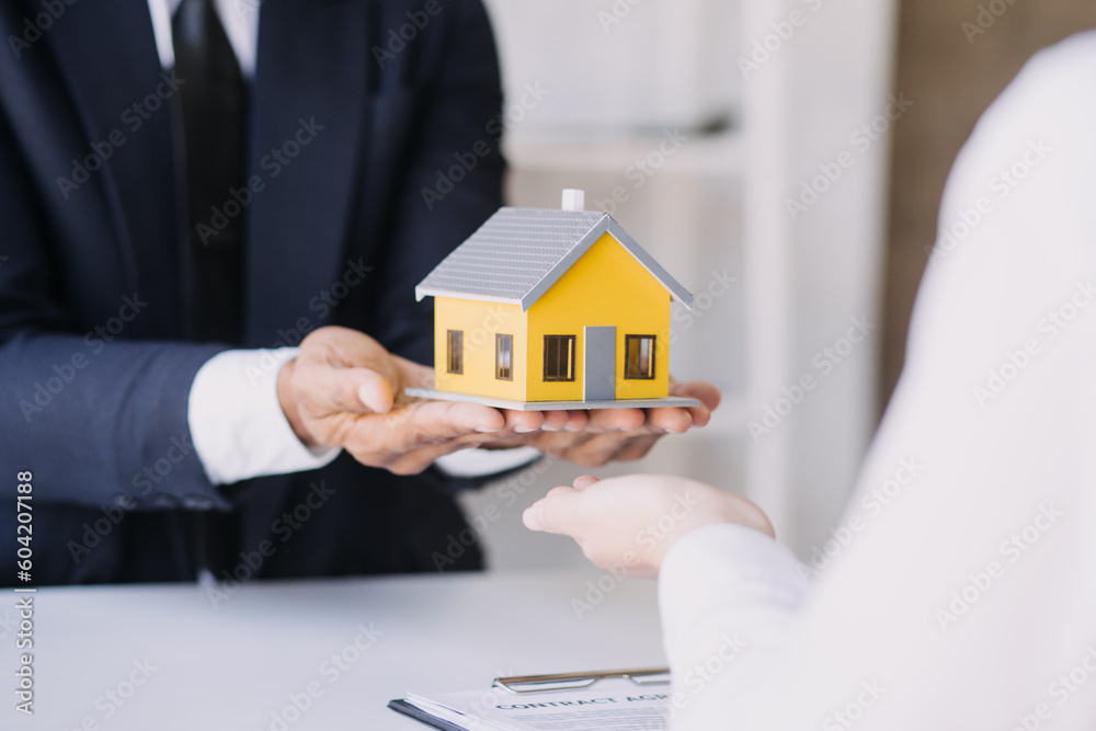 A couple is approaching a housing project to buy, and they are discussing details and advice with a salesperson in a housing project. Real estate trading ideas with couples. A couple is approaching a housing project to buy, and they are discussing details and advice with a salesperson in a housing project. Real estate trading ideas with couples.