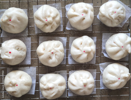 top view of group of Steamed Buns laying on stainless tray at food industry factory, pre-cook food business.