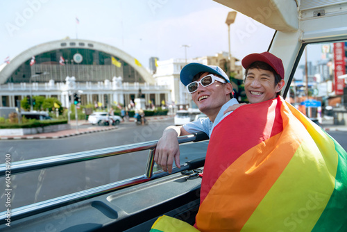 Photography LGBTQ couple with rainbow flag spending time together traveling on bus tour, Hua