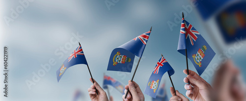 A group of people holding small flags of the Cayman Islands in their hands