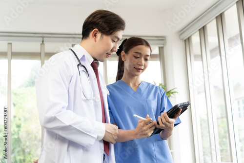 Professional Doctor Man In White Uniform and young female surgeon doctor with tablet