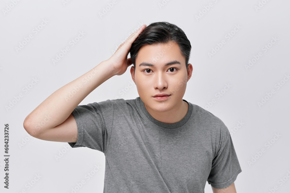 Portrait of handsome man with beaming smile touching his hair Portrait of handsome man with beaming smile touching his hair