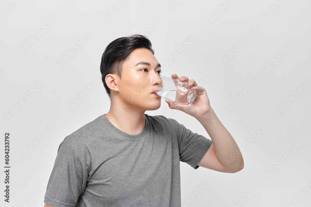 Young man hydrating himself with a glass of water Young man hydrating himself with a glass of water