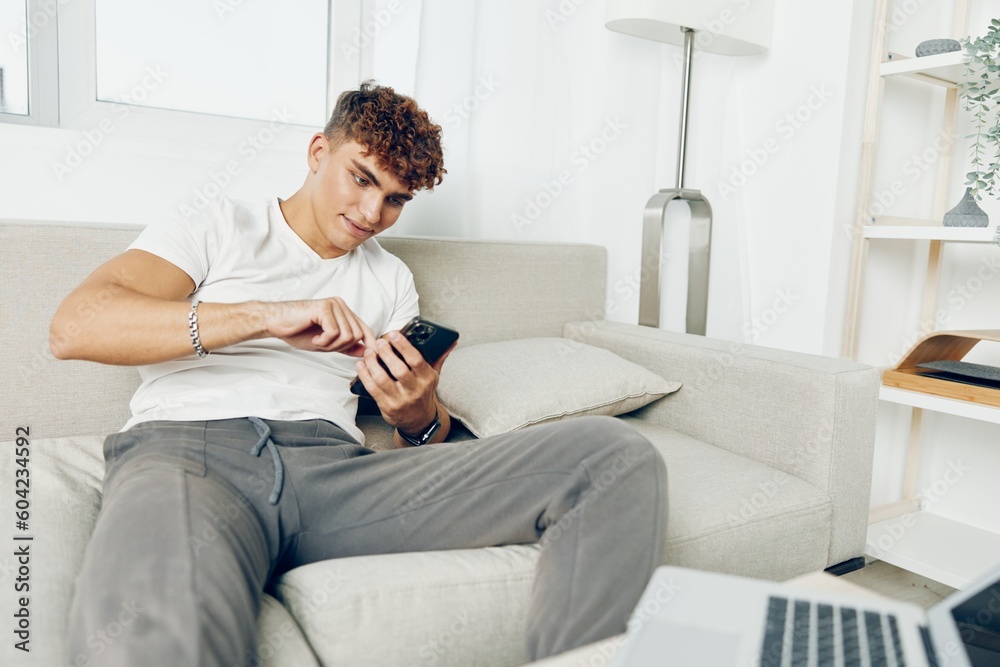 man interior home using smile young laptop phone sitting internet cyberspace student