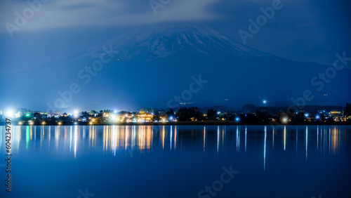 暗闇に浮かび上がる富士山と夜中の河口湖に映る夜景