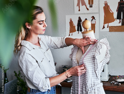 Fashion, sustainable business and woman designer with mannequin, measuring tape and creative startup. Focus, creativity and tailor with dress on doll, eco friendly design on clothes in textile studio