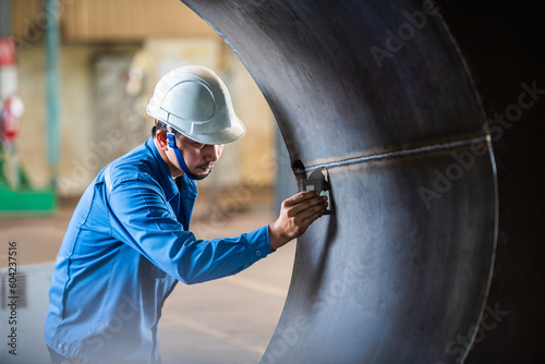 QC Technician inspector using welding gauge inspection butted weld on plate steel structure in industry fabrication factory. NDT