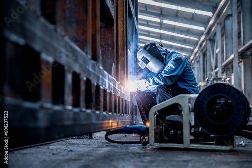 Industrial welder welding fabricated construction in factory, Welding process by Flux Core Welding, FCAW