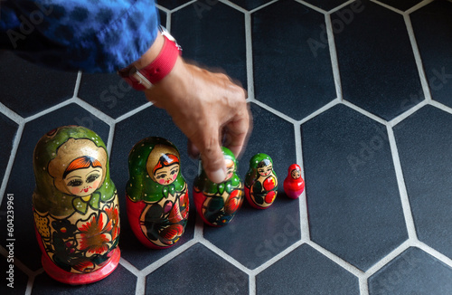 Russian Russian matriochka dolls in a row with a hand moving one photo