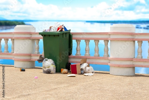 Plastic bin full of garbage on the bridge. Plastic waste, glass bottle, paper, carton box, food waste and other were littered in bucket and overflowing.