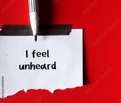 Pen write on a stick note I FEEL UNHEARD, means to feel like nobody listens, feeling unheard by others around, your voice has not taken into account photo