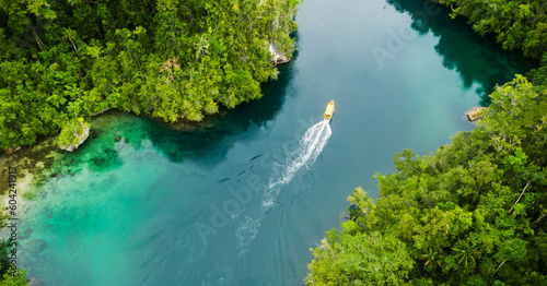 Island, tropical and drone of a boat in nature with trees for sailing on vacation or weekend trip. Travel, adventure and aerial view of speedboat on a river of resort water for summer holiday.