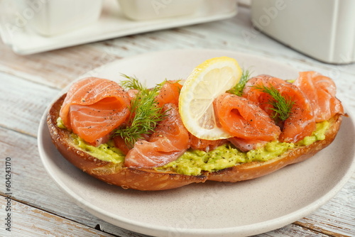 Avocado toast with salmon, lemon, and dill on the plate.