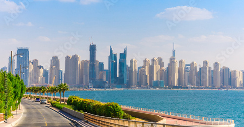 View of Dubai with palm trees and skyscrapers. Sunny summer day in UAE