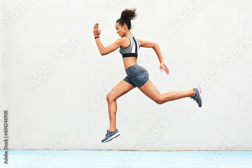 Woman  fitness and running on mockup of athlete in cardio training  workout or healthy exercise. Fit  active or sporty female person or runner exercising for health and wellness on wall mock up space