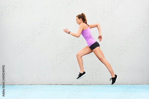 Woman, fitness and running on mockup for workout, cardio training or healthy exercise outdoors. Fit, active and sporty female person or runner exercising for health and wellness on wall mock up space