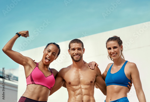 Flexing, muscle and portrait of fitness friends with blue sky at outdoor gym with fit smile and power in summer. Workout, exercise and personal trainer man with women, happiness and healthy mindset.