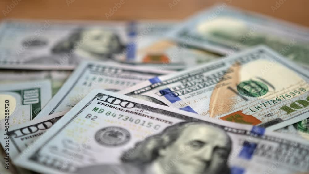 100 American dollars bills paper money cash. Many hundred dollar lies on wooden table. Importance of financial management in achieving long-term financial goals. 100 American dollars bills paper money cash. Many hundred dollar lies on wooden table. Importance of financial management in achieving long-term financial goals.