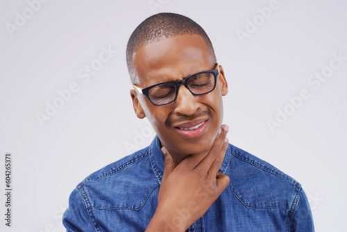 Black man, sore throat and virus in pain, allergies or bacteria against a white studio background. Sick African male person touching neck from cough, allergy or flu of cold, illness or infection