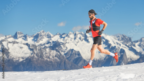 Trail running athlete runs in the snow