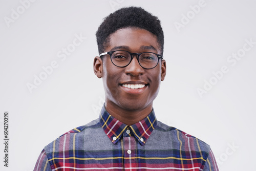 Smile, portrait of black man with glasses and happy against a white background. Nerd or geek, happiness and African male smiling with proud facial expression against a studio backdrop for confidence