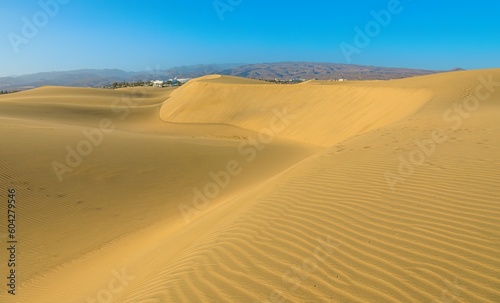 Maspalomas Dunes of Gran Canaria, desert oasis in the heart of Canary Islands, captivates visitors with its towering dunes, stunning sunset vistas, and panoramic views of surrounding natural beauty.