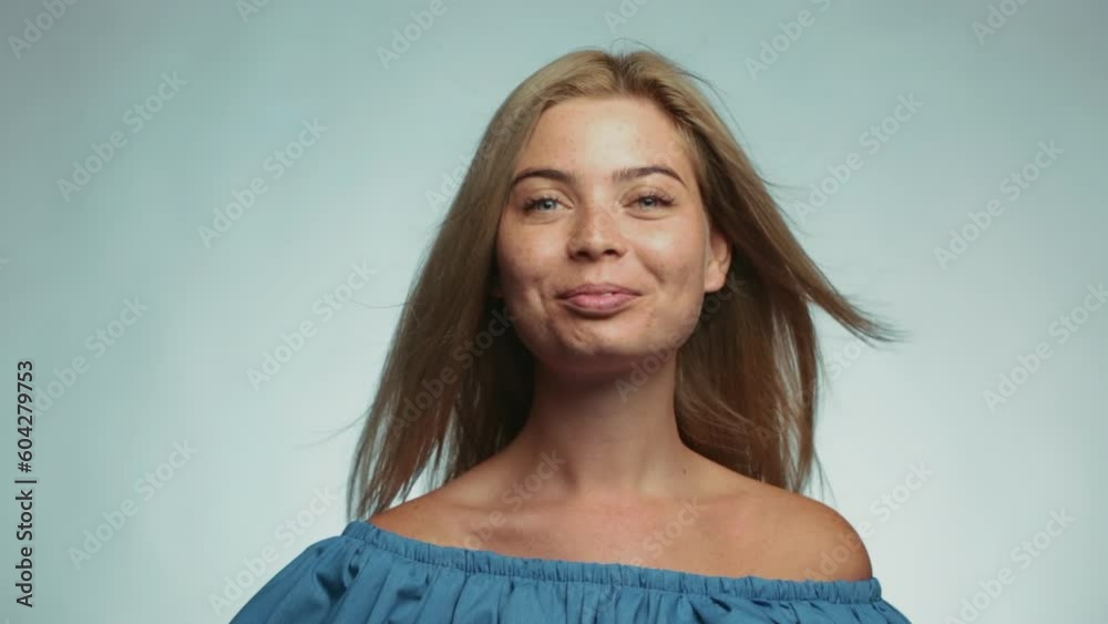 Beautiful girl with freckles shows emotions in front of the camera on a white background