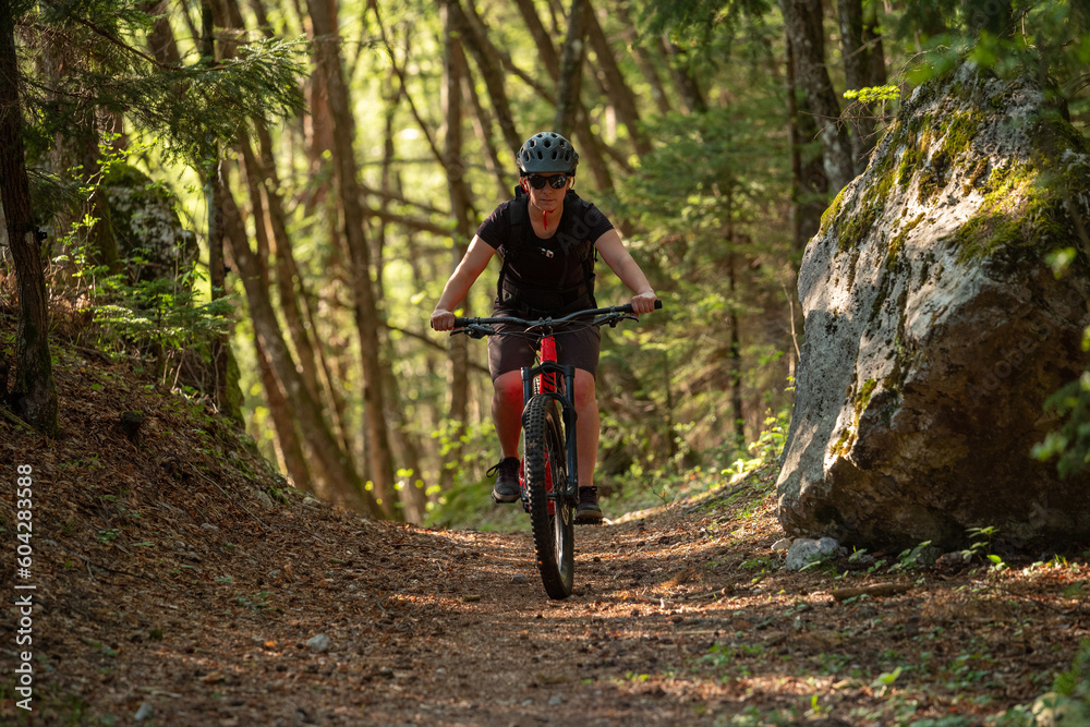 Female cyclist on her mountain bike riding through the hills on a sunny day.