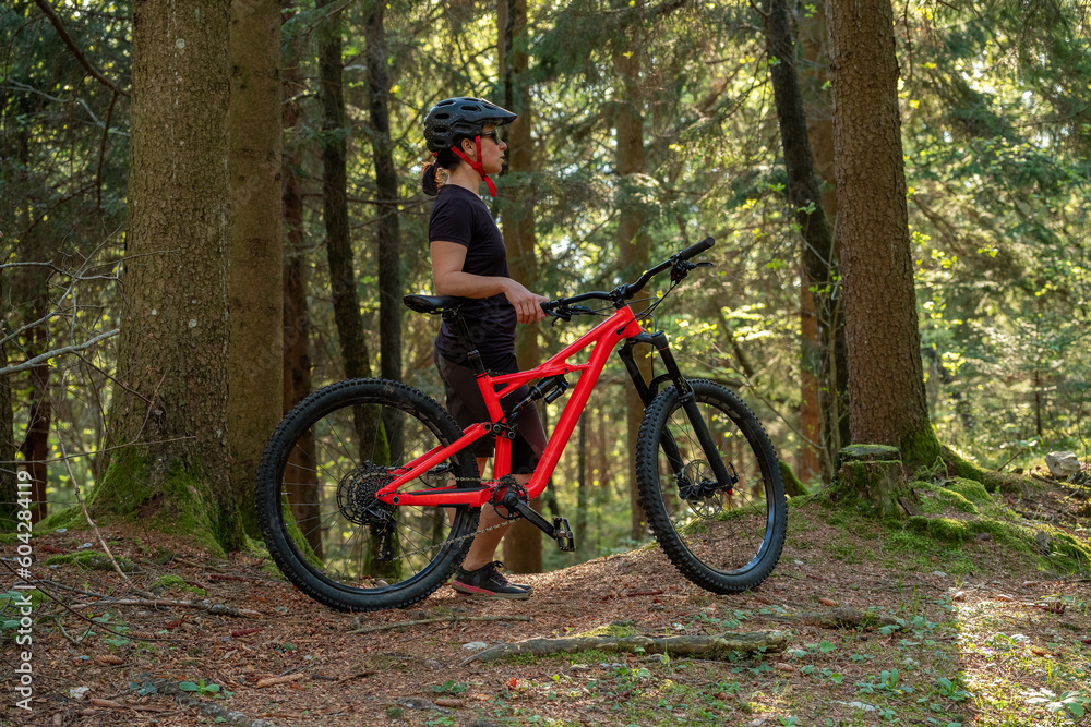 Female cyclist on her mountain bike riding through the hills on a sunny day.